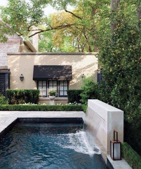 a modern waterfall coming from a stone slab into a pool is a gorgeous addition to your swimming experiences