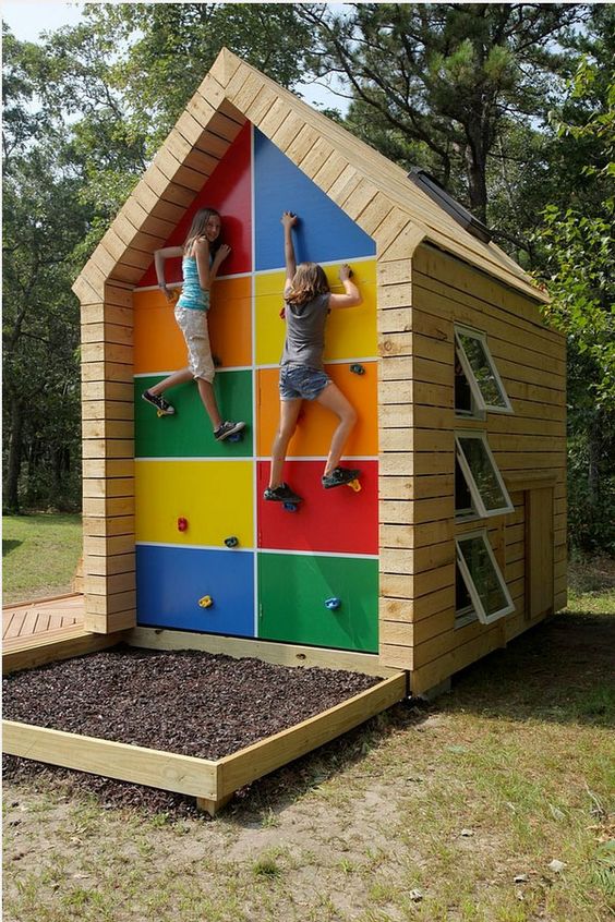 a colorful garden house for kids, with windows and a small yet cool climbing wall that hides storage space at the same time a colorful garden house for kids, with windows and a small yet cool climbing wall that hides storage space at the same time