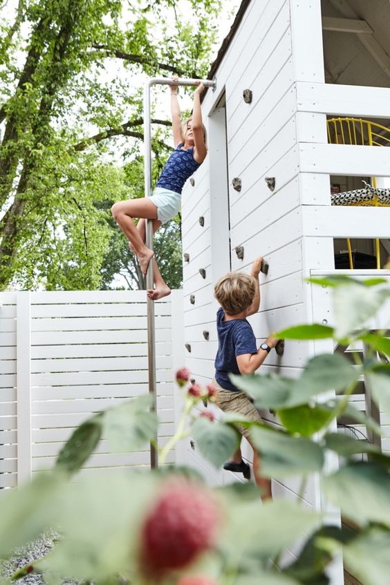 a kids' house in the garden with a climbing wall to let kids play and have fun here in many ways a kids' house in the garden with a climbing wall to let kids play and have fun here in many ways