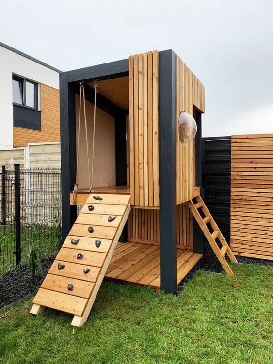 a modern light stained kids' house with a ladder and a climbing wall and a sphertic window is a lovely idea a modern light-stained kids' house with a ladder and a climbing wall and a sphertic window is a lovely idea