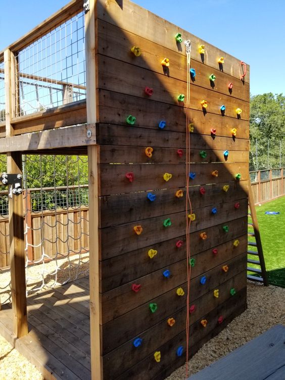 a backyard climbing wall including netting wall with a platform on top is a great idea to realize for your kids