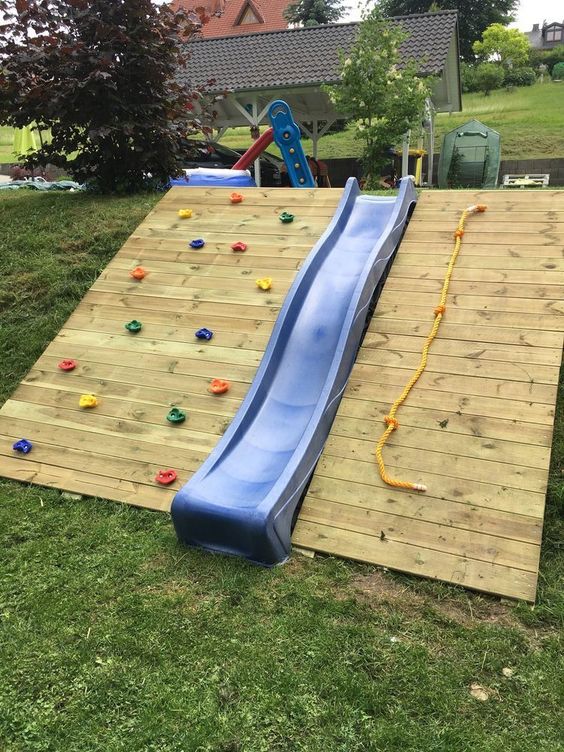 a colorful climbing wall, a blue slide and a rope is a simple and cool complex for kids to have fun and activities