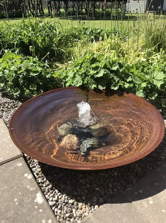 a super simple modern bowl fountain with rocks on the bottom is a great water feature for a modern garden, and your pets can refresh themselves in it