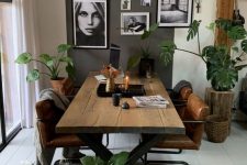 a Nordic dining room with a planked table and leather chairs, a rug, some baskets and a black and white gallery wall