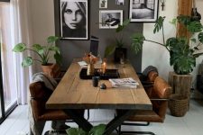 a Nordic dining room with a planked table and leather chairs, a rug, some baskets and a black and white gallery wall