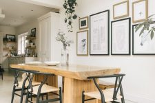 a Scandinavian dining space with a wood slab table, chic mid-century modern chairs, an elegant monochromatic gallery wall
