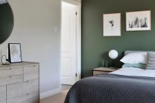 a bedroom with a green accent wall, a grey bed with bold bedding, a whitewashed dresser and a mini gallery wall for an eye-catchy touch