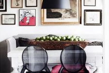a bold Scandinavian dining room with a white vintage table, black sheer chairs, a black pendant lamp and a gorgeous oversized gallery wall