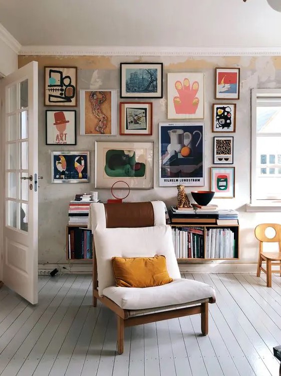 a bold and jaw-dropping gallery wall with lots of abstract art in mismatching frames gives a character to this neutral space