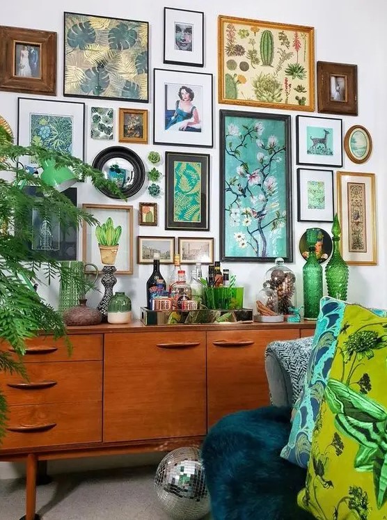 a botanical gallery wall with various art in mismatching frames and even faux succulents right on the wall is wow