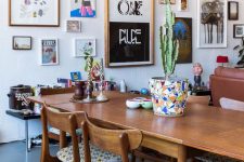 a catchy modern dining room with stained furniture, a colorful gree form gallery wall and potted plants