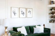 a chic mid-century modenr living room with built-in shelves and cabinets, a green sofa, brown leather chairs, chic tables and a mini gallery wall