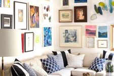 a colorful gallery wall taking two walls with mismatching frames and super bold artworks in various styles and in various colors