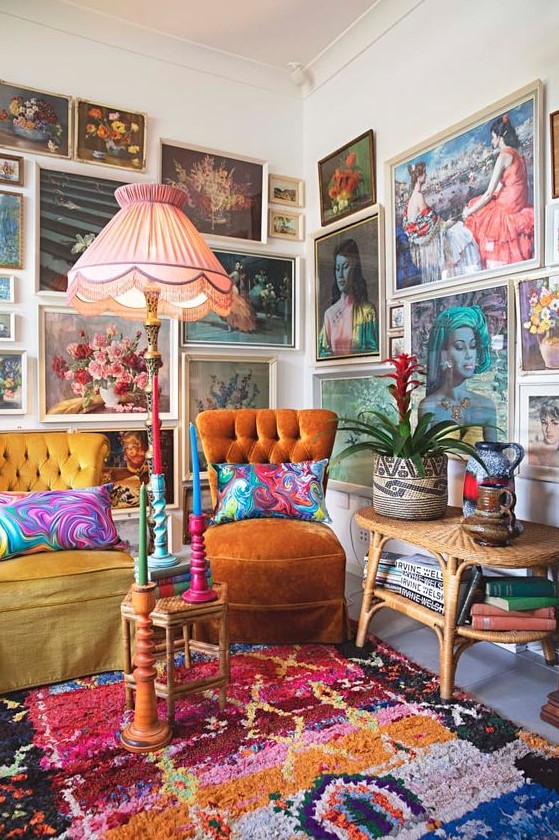 a colorful gallery wall taking two walls, with vintage paintings in neutral frames, with portraits and botanicals is amazing