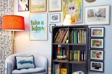 a colorful gallery wlal with mismatching frames, a creative form, a gold bead monogram and some posters is fun
