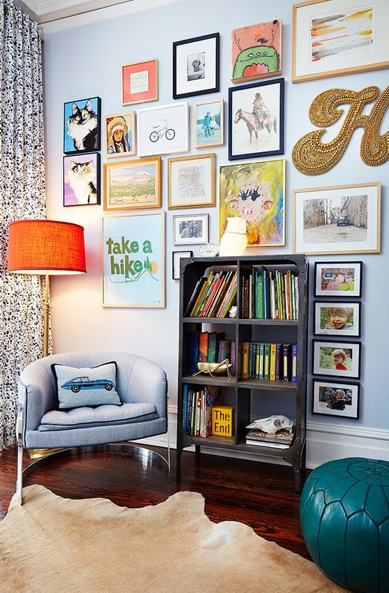 a colorful gallery wlal with mismatching frames, a creative form, a gold bead monogram and some posters is fun