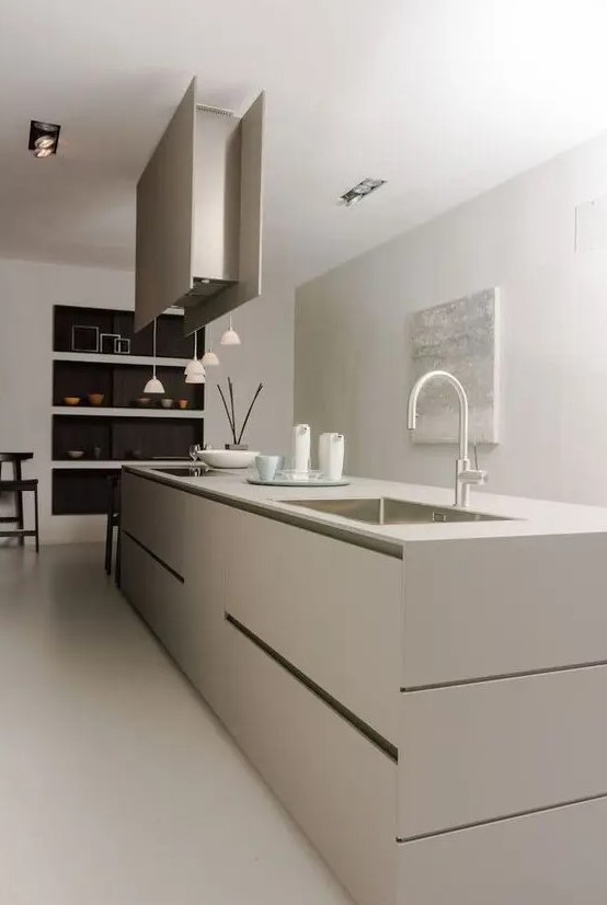 a contemporary to minimalist kitchen done in greige, with a sleek kitchen island, a hood, pendant lamps, niche shelves is amazing