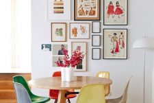 a cool and bright dining room with a stained table and colorful chairs, a bold gallery wall and bright blooms