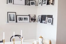 a corner gallery wall with black and white artworks in black frames adds personality to the space and makes it cozier