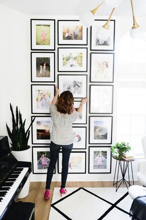 a creative grid gallery wall with matching black frames and colored family pics is a cool idea for a modern space