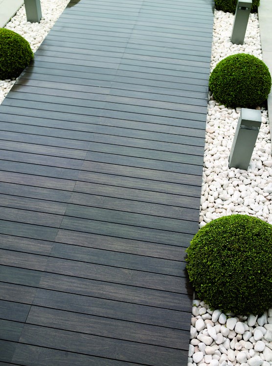 a dark stained wooden path contrasts white pebbles lining and boxwood looks ultra modern and bold a dark stained wooden path contrasts white pebbles lining and boxwood looks ultra-modern and bold