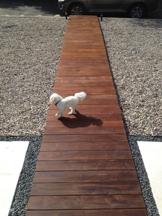 a dark stained wooden walkway is a chic and stylish idea for a modern outdoor space, gravel around adds texture to the space a dark-stained wooden walkway is a chic and stylish idea for a modern outdoor space, gravel around adds texture to the space