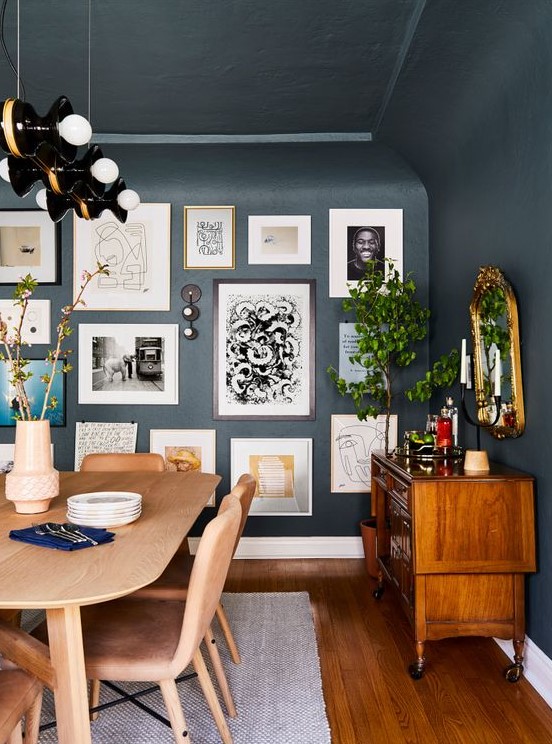 a free form gallery wall with framed and non framed artworks, posters and prints plus some wall sconces is pure chic