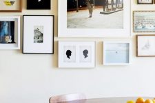 a free form gallery wall with thin black, white and wooden frames and white matting but mismatching black and white and color art