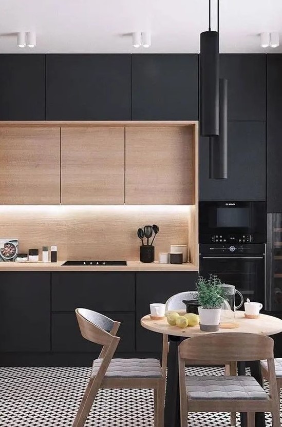a gorgeous contemporary kitchen with sleek black cabinets, a row of light stained ones, built-in lights and black tube pendant lamps over the dining space