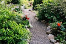 a gravel garden path lined with large rocks that help to keep the gravel in place and add a wild look