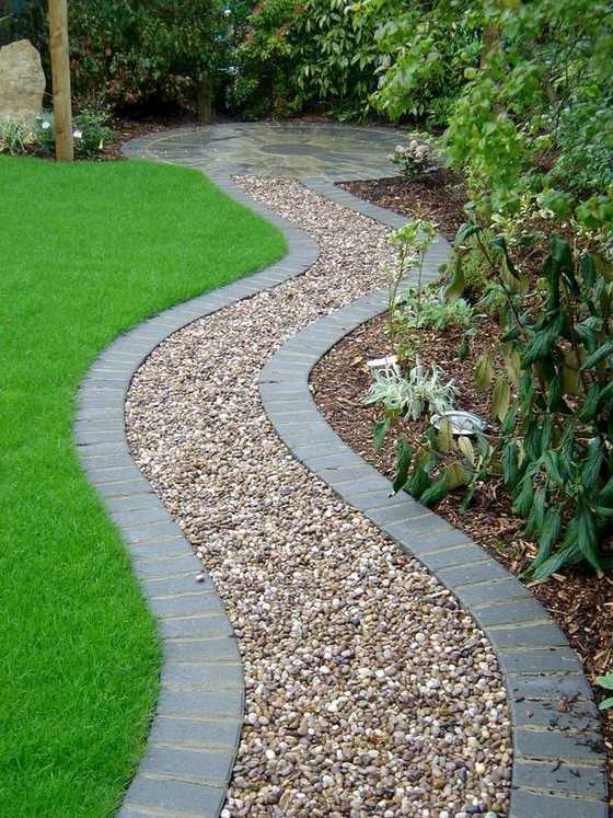a gravel gardne path lined with bricks to keep gravel in place and make it look neat