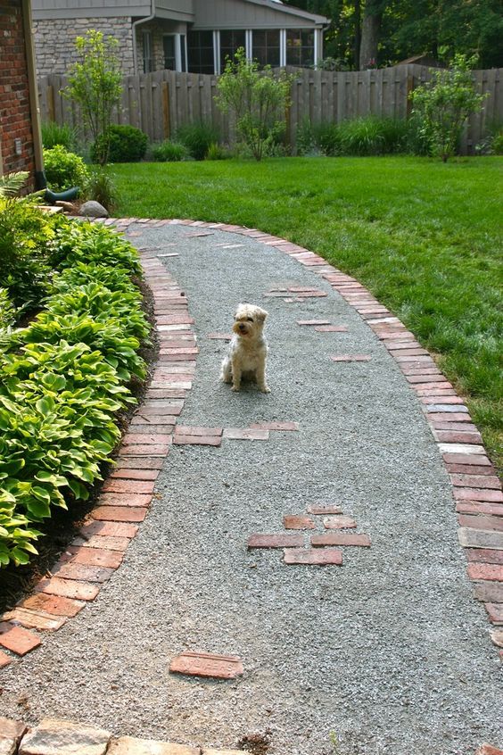 a gravel pathway with brick borders lined up with green lawn and greenery on the other side is a cool idea to welcome people