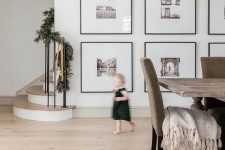 a large gallery wall with thin black frames, large matting and black and white photos is a very artful idea