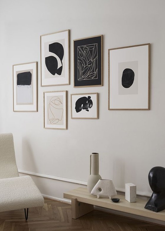 a minimalist gallery wall with a free form and matching stained frames of various sizes is a cool idea for a modern space