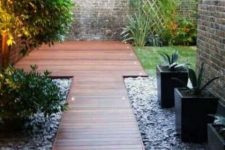 a minimalist rich-stained wooden planked walkway with built-in lights is a stylish idea for a modern or contemporary space, and lights will make walking at night comfortable