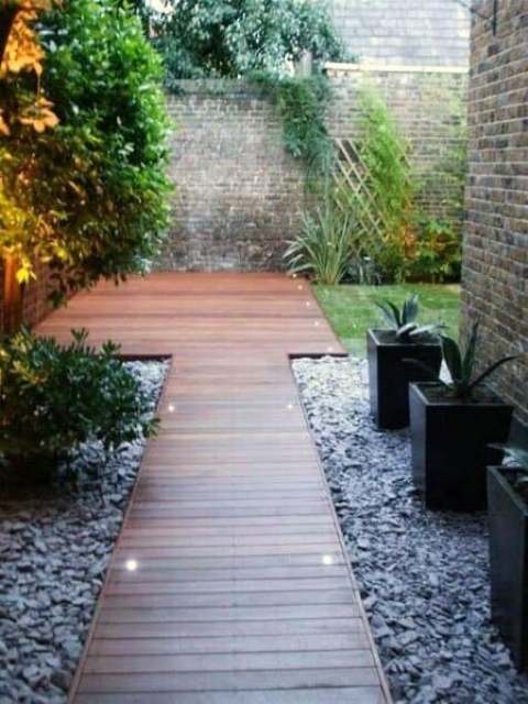 a minimalist rich-stained wooden planked walkway with built-in lights is a stylish idea for a modern or contemporary space, and lights will make walking at night comfortable