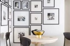 a modern and elegant free form gallery wall covering a whole corner and with matching black frames and white mats is wow