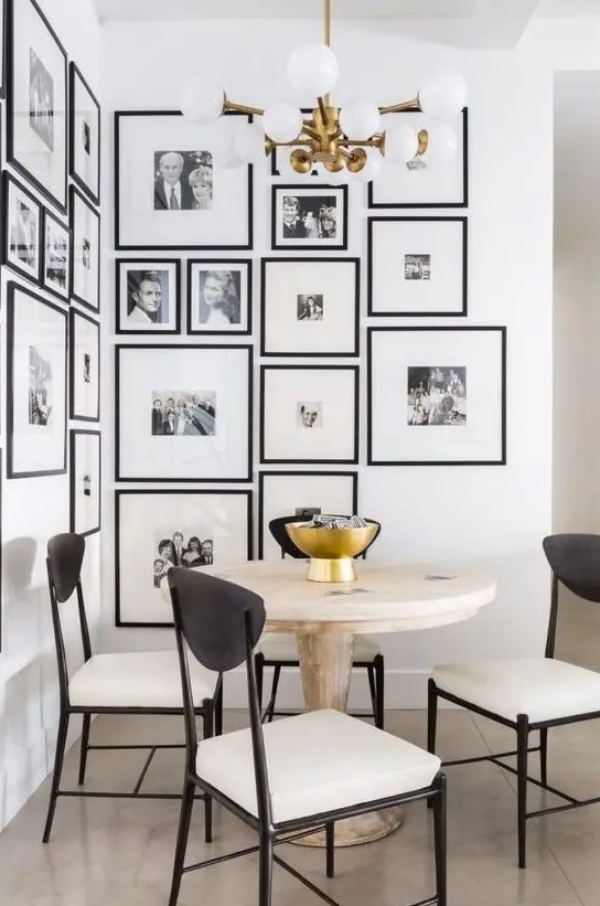 a modern and elegant free form gallery wall covering a whole corner and with matching black frames and white mats is wow