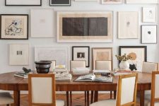a neutral vintage dining room with a stained table and creamy chairs, a large free form gallery wall and some dried blooms