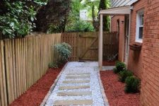 a pretty and catchy walkway with neutral pebbles, wooden steps and brick edges is a lovely idea for a rustic space