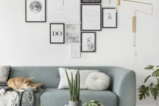 a pretty modern gallery wall with mismatching black and white frames and a free form looks fresh thanks to the artworks chosen