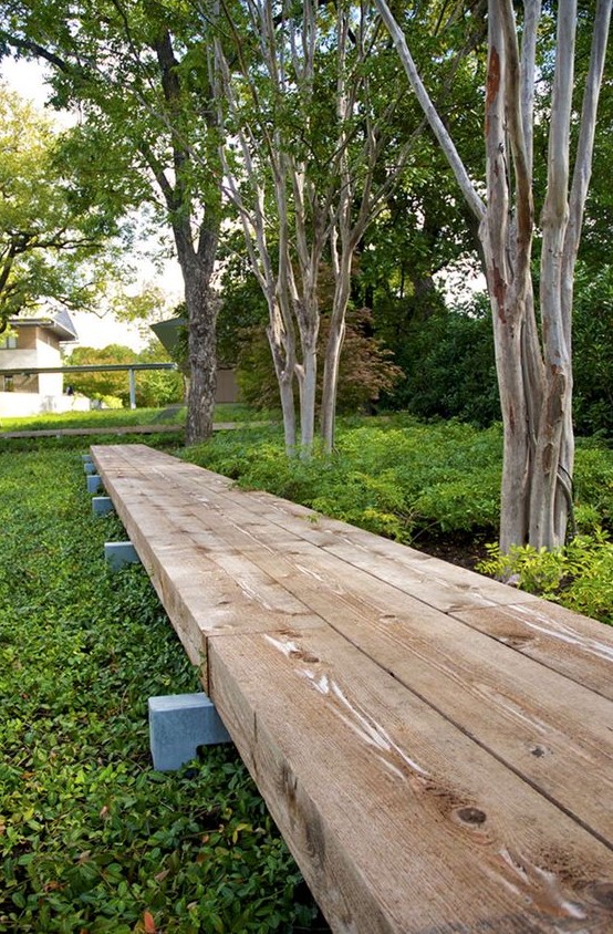 a raised wooden pathway is a comfortable and welcoming idea for any modern garden, especially if you have lots of rain or snow