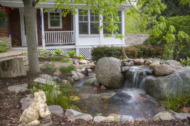 a recirculating waterfall in the front yard and a frog statuette to mark the outdoor space