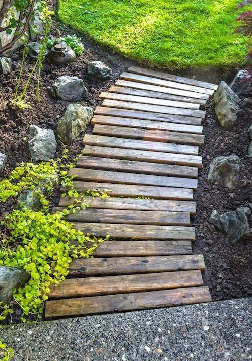 a reclaimed wood garden path with rocks and greenery around is a gerat soluton for a rustic inspired space