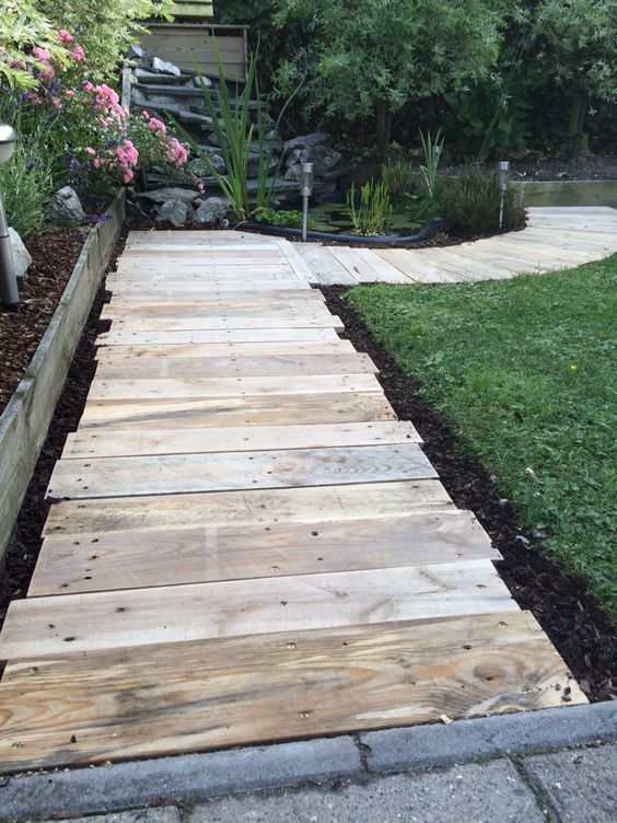 a reclaimed wooden walkway of pallets is a perfect idea for a rustic outdoor space, it will make your garden cozier