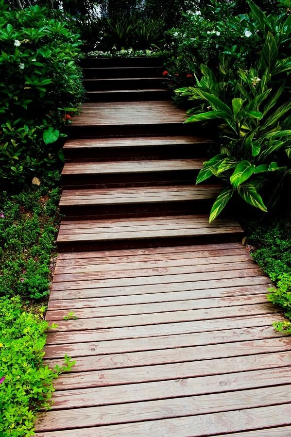 a simple stained planked wooden walkway with steps is a classic idea for any garden, from a modern to a zen like one