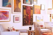 a statement and colorful gallery wall with large scale and bold artworks in mismatching frames is a lovely idea
