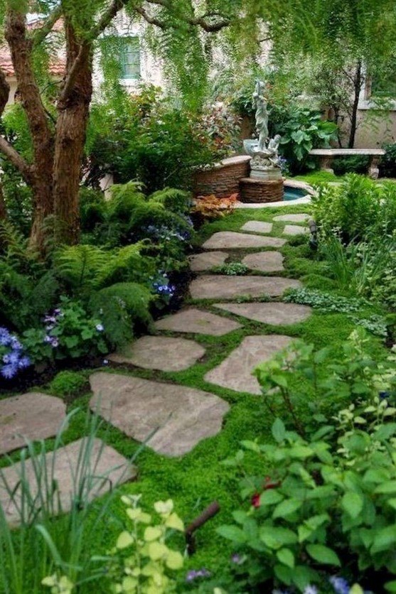 a stone front yard pathway with moss in between and around for a welcoming and beautiful space