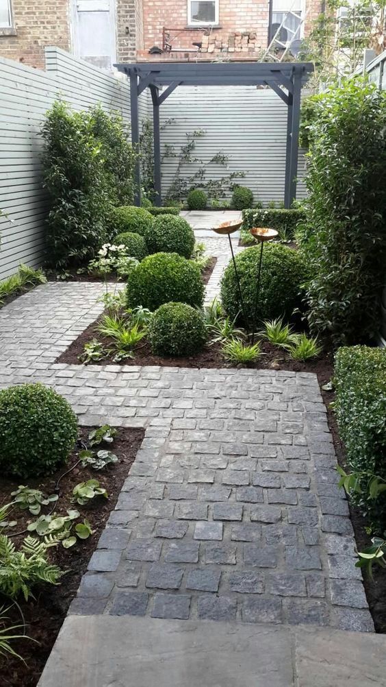 a stone pathway lined up with greenery and accurate bushes plus some lights looks amazing