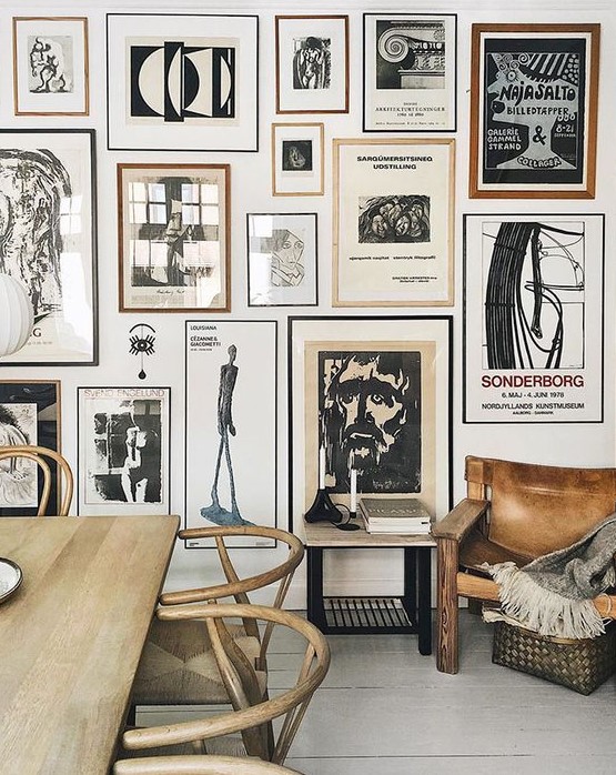 a stunning gallery wall with thin black and brown frames and black and white artworks is a bold eye-catcher